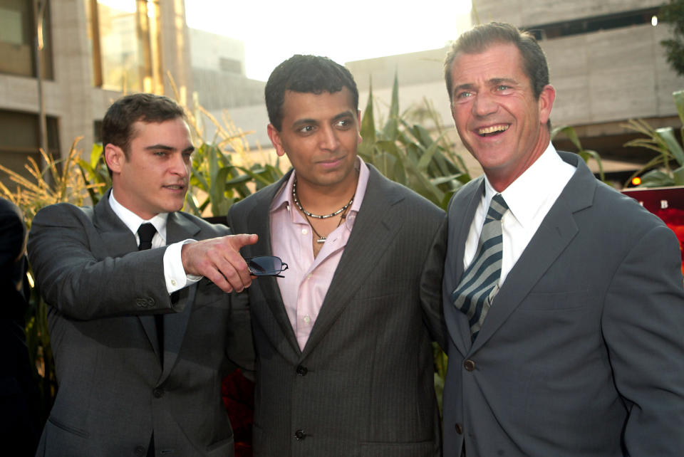 Actors Joaquin Phoenix and Mel Gibson with director M. Night Shyamalan at the "Signs" World Premiere at Alice Tully Hall  in New York City. July 29, 2002.  Photo: Evan Agostini/ImageDirect