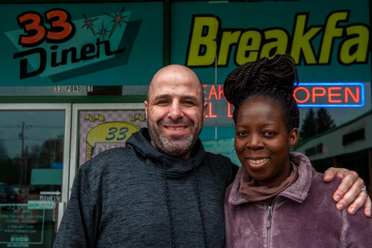 Peter and Norah Zoummar pose for a photo outside the 33 All American Diner in Ashland, which they own, April 3, 2024. Norah was recognized last week at the State House and received a Black Excellence Award, which is sponsored by the Massachusetts Black and Latino Legislative Caucus. A Ugandan singer, she raises money to support women's causes in her home village of Namwendwa.