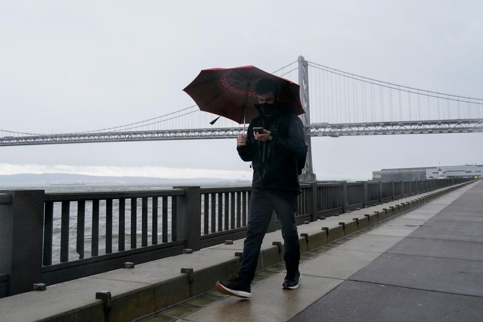 A person is pictured walking on The Embarcadero in San Francisco,  Another winter storm is expected to move into California on Wednesday, walloping the northern part of the state with more rain and snow.