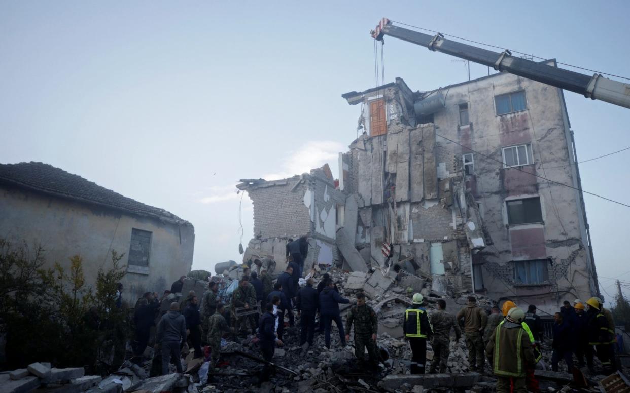 Emergency personnel work near a damaged building in Thumane, after an earthquake shook Albania - REUTERS