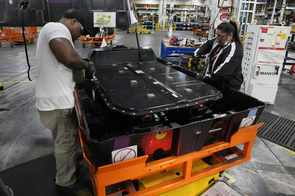 File - Assembly line workers uncrate an LG battery at the General Motors Orion Assembly, June 15, 2023, in Lake Orion, Mich. Over the past year, paychecks outpaced inflation, thereby easing Americans' adjustment to a higher cost of living. (AP Photo/Carlos Osorio, File)