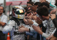 Mercedes driver Lewis Hamilton of Britain, left, is congratulated by his team members after the Chinese Formula One Grand Prix at Shanghai International Circuit in Shanghai, Sunday, April 20, 2014. (AP Photo/Eugene Hoshiko)