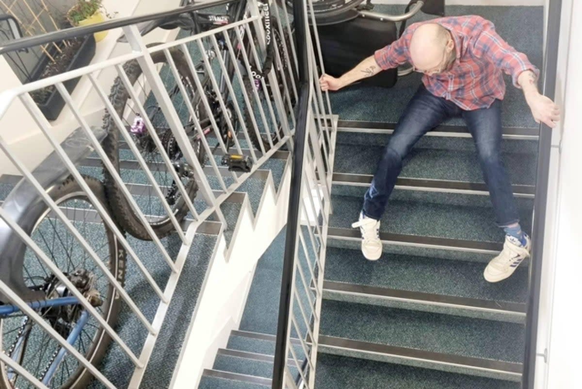 Chris Purnell dragging himself down the stairs of his block of flats in Granton, Edinburgh. (Courtesy of Chris Purnell / SWNS)