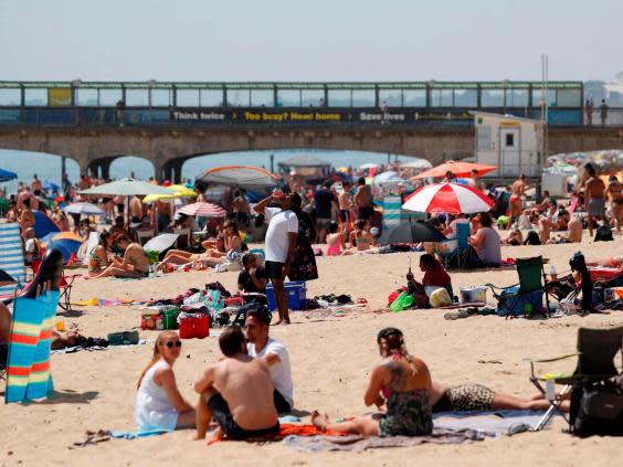 (Sunbathers enjoy the sunny weather on Boscombe beach (ADRIAN DENNIS/AFP via Getty Images)