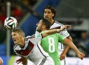 Germany's Bastian Schweinsteiger (L) and Sami Khedira (R) fight for the ball against Algeria's Mehdi Lacen during extra time in their 2014 World Cup round of 16 game at the Beira Rio stadium in Porto Alegre June 30, 2014. REUTERS/Darren Staples