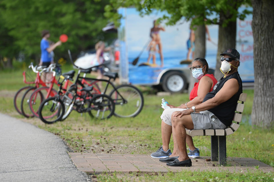 MARYLAND HEIGHTS, MO - MAY 25: A man and woman sit with their masks on at Creve Coeur Lake Park on May 25, 2020 in Maryland Heights, Missouri. Many people flocked to certain area parks to relax and exercise amid COVID-19 social distancing guidelines.  (Photo by Michael Thomas/Getty Images)