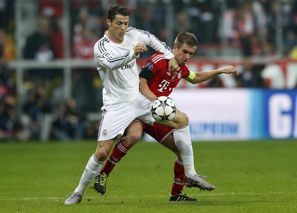 Real's Cristiano Ronaldo, left, and Bayern's Philipp Lahm challenge for the ball during the Champions League semifinal second leg soccer match between Bayern Munich and Real Madrid at the Allianz Arena in Munich, southern Germany, Tuesday, April 29, 2014. (AP Photo/Matthias Schrader)