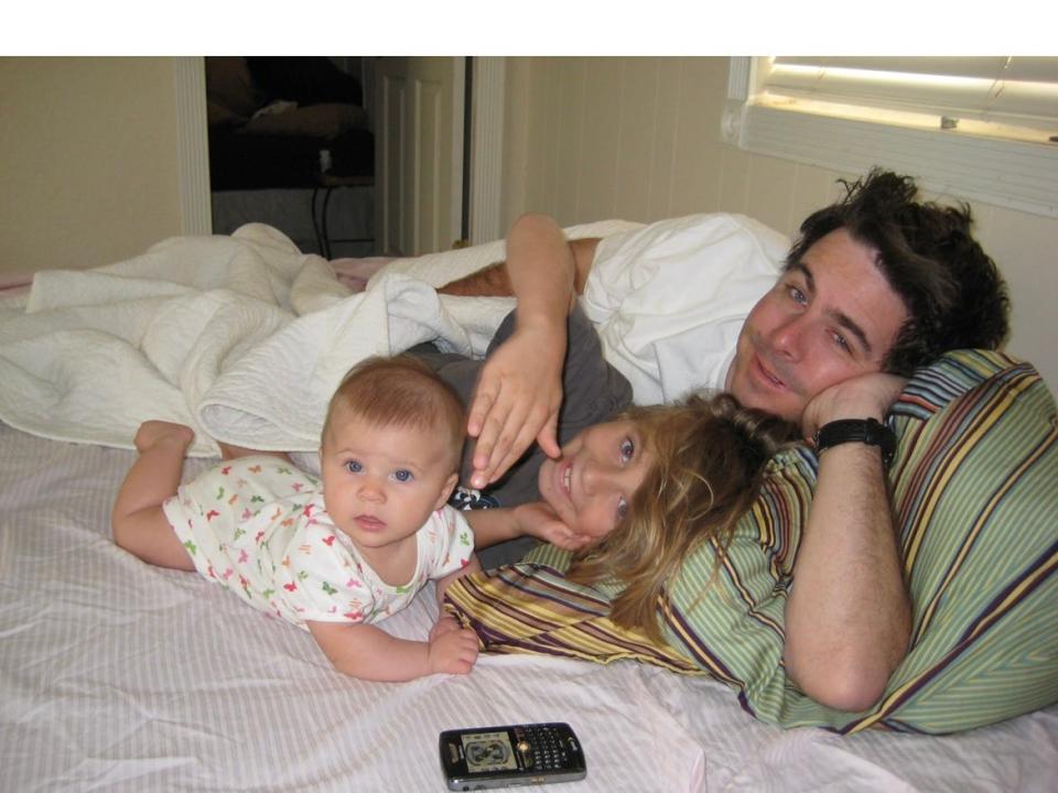 Gavin Alsop lies in bed, his head propped up on a cushion, with his son, Gavin, and second child, Piper in 2009.