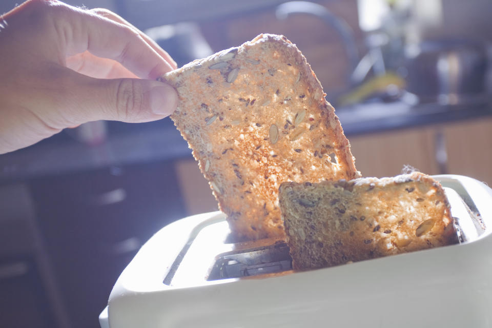 Woman hand holding slice of Whole grain toast.