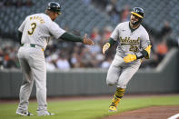 Oakland Athletics' Shea Langeliers (23) celebrates after his home run with third base coach Eric Martins (3) during the first inning of a baseball game against the Baltimore Orioles, Friday, April 26, 2024, in Baltimore. (AP Photo/Nick Wass)