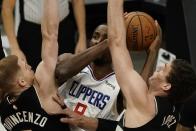 LA Clippers' Serge Ibaka tries to shoot between Milwaukee Bucks' Donte DiVincenzo and Brook Lopez during the first half of an NBA basketball game Sunday, Feb. 28, 2021, in Milwaukee. (AP Photo/Morry Gash)