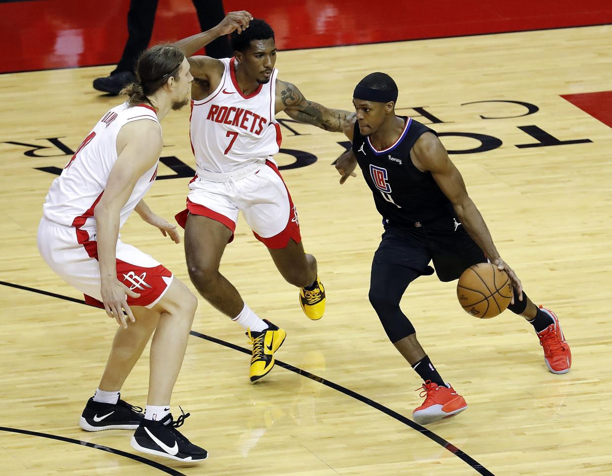 Rajon Rondo #4 of the LA Clippers drives on Armoni Brooks #7 of the Houston Rockets and Kelly Olynyk #41 during the second quarter at Toyota Center on May 14, 2021 in Houston, Texas. NOTE TO USER: User expressly acknowledges and agrees that, by downloading and or using this photograph, User is consenting to the terms and conditions of the Getty Images License Agreement. (Photo by Bob Levey/Getty Images)