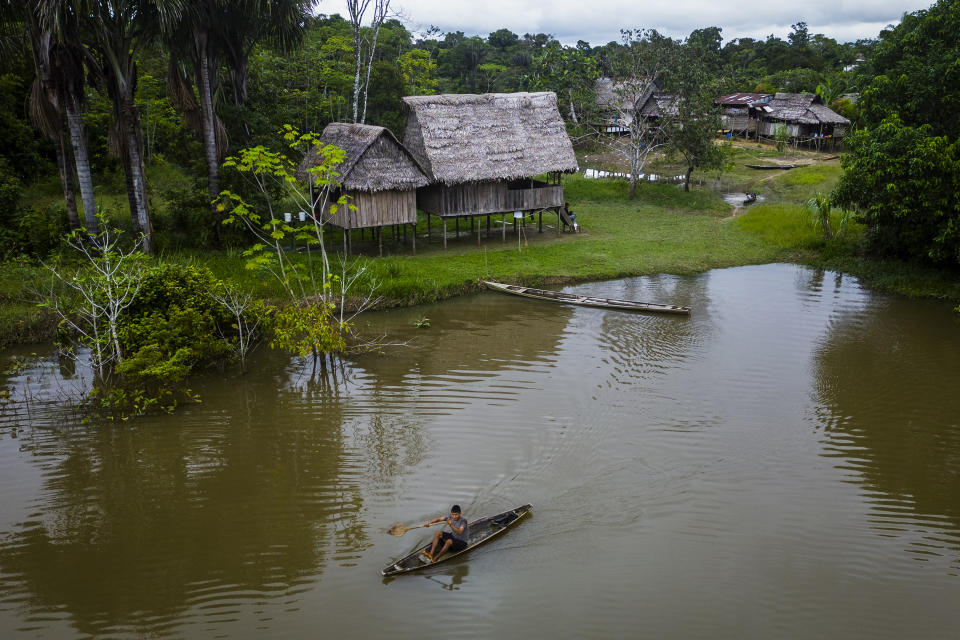 A Maijuna youth paddles his canoe on a stream in Sucusari, Peru, Thursday, May 30, 2024. A federal highway project in an untouched area of the Peruvian Amazon is facing mounting opposition from Indigenous tribes, including the Maijuna. (AP Photo/Rodrigo Abd)