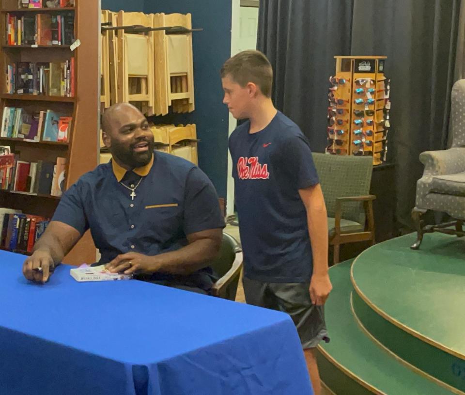 Former Ole Miss football All-American Michael Oher, subject of ‘The Blind Side’, speaks to a fan at his book signing in Oxford on Tuesday.