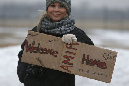 Flint resident Stephanie Walker holds a 'Welcome Home' sign outside the airport where former U.S. Marine Amir Hekmati, recently released from an Iranian prison, arrived in Flint, Michigan January 21, 2016. REUTERS/Rebecca Cook