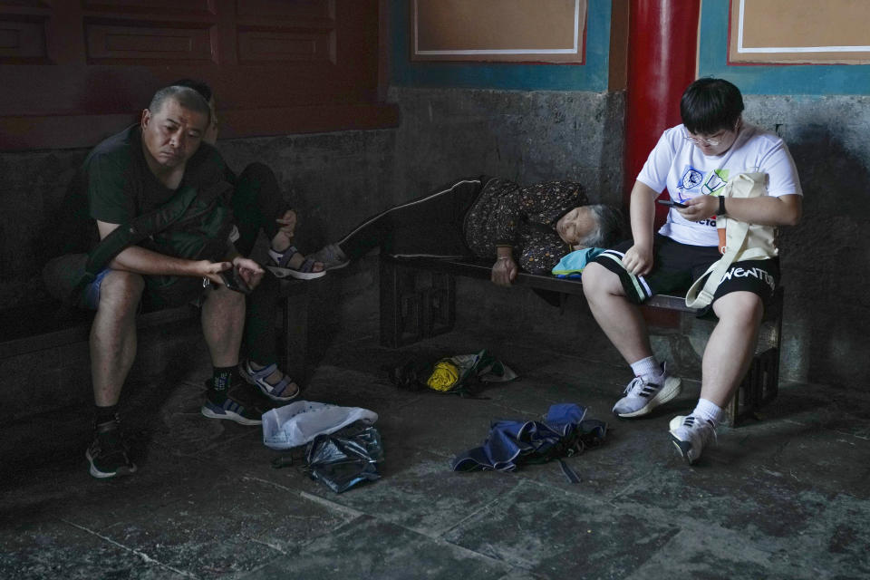 Visitors rest inside a hall of the Garden of the Palace of Compassion and Tranquility, known as Dining gong huayuan, at the Forbidden City in Beijing on Thursday, July 13, 2023. (AP Photo/Andy Wong)