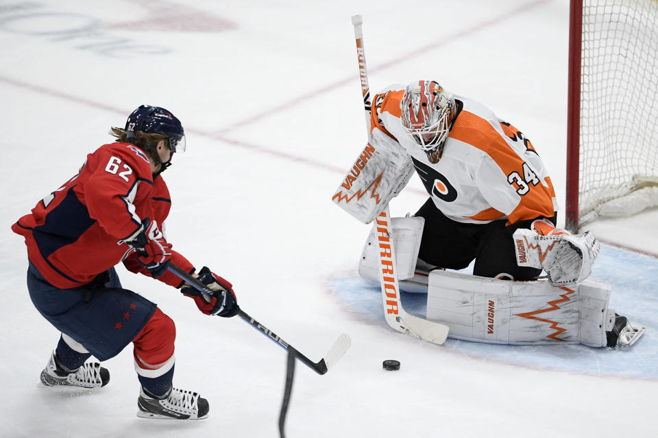 Washington Capitals left wing Carl Hagelin (62) tries to get the puck past Philadelphia Flyers goaltender Alex Lyon (34) during the second period of an NHL hockey game Saturday, May 8, 2021, in Washington. (AP Photo/Nick Wass)