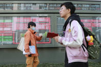 People walk by an electronic stock board of a securities firm in Tokyo, Monday, March 1, 2021. Asian shares were higher on Monday on hopes for President Joe Biden’s stimulus package and bargain-hunting buying after the shares’ fall last week. (AP Photo/Koji Sasahara)