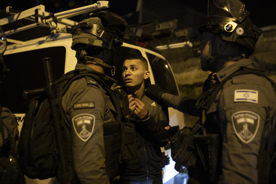 A Palestinian youth pleas with Israeli police after he was detained at a protest against the forcible eviction of Palestinian families from their homes in the Sheikh Jarrah neighborhood of Jerusalem, Thursday, May 6, 2021. Palestinians and Israeli settlers hurled rocks and chairs at each other in Sheikh Jarrah, where dozens of Palestinians are at risk of being evicted following a long legal battle with Jewish settlers trying to acquire property in the neighborhood, which is just north of Jerusalem's Old City. (AP Photo/Maya Alleruzzo)