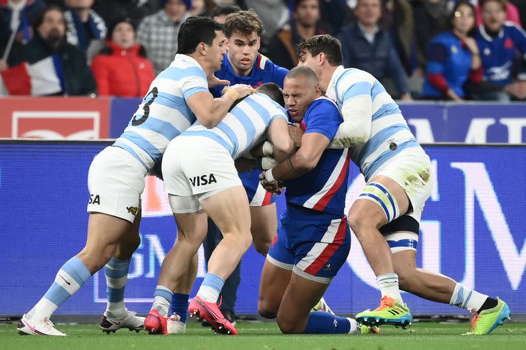 Tres jugadores de Los Pumas empujan para evitar el avance del francés Gael Fickou durante el partido que los galos ganaron por 29-20, disputado en el Stade de France.