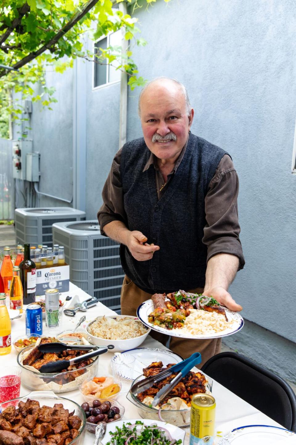 Alex Khachoyan is showing his plate of grilled meats.