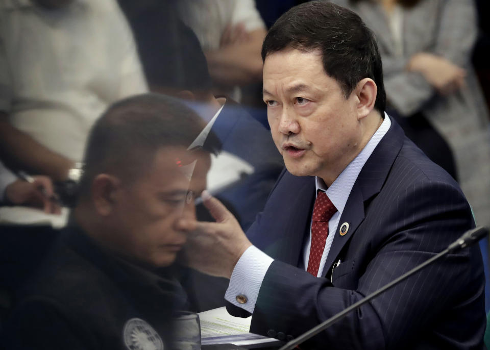 In this photo taken on Monday, Sept. 2, 2019, Nicanor Faeldon, left, the Director General of the Bureau of Corrections, is reflected on the marbled wall of the Senate as Justice Secretary Menardo Guevarra expounds on his answers during the Senate probe on the failed release of former Mayor Antonio Sanchez, who was convicted in the rape and murders of two students in 1993, in suburban Pasay city south of Manila, Philippines. Philippine President Rodrigo Duterte has fired Faeldon Wednesday, Sept. 4, 2019 amid a public outcry over the release of hundreds of prisoners, including convicted rapists and drug traffickers, through a law rewarding good behavior in detention. (AP Photo/Bullit Marquez)