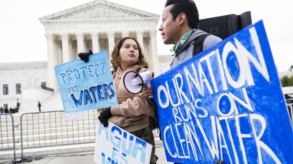 Jaime Sigaran and his sister Bethsaida at a rally outside the Supreme Court, holding signs saying Protect Our Waters, and Our Nation Runs on Clean Water.