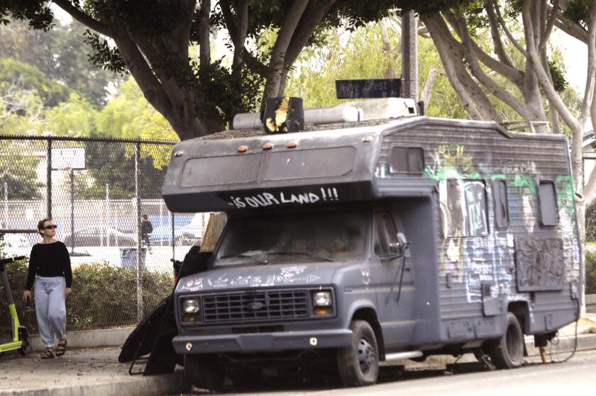 VENICE, CA - SEPTEMBER 8, 2021 - A pedestrian looks over an RV that has been a concern for residents in the area along Main Street in Venice on September 8, 2021. Ray White, Jr., lives in the parked RV. Attorney Stephen Yagman has filed several lawsuits on White's behalf with one being a lawsuit against RV parking restrictions. Yagman was a high-powered civil rights attorney until his conviction on fraud charges and subsequent 2010 disbarrment. At age 75, Yagman has re-passed the bar exam and won reinstatement to practice law. He's starting out hard with a flurry of new cases including White's. (Genaro Molina / Los Angeles Times)