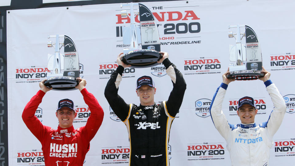 Podium finishers Marcus Ericsson, second place, Josef Newgarden, race winner and Alex Palou, third place, raise their trophies in Victory Lane during an IndyCar race at Mid-Ohio Sports Car Course in Lexington, Ohio, Sunday, July 4, 2021. (AP Photo/Tom E. Puskar)