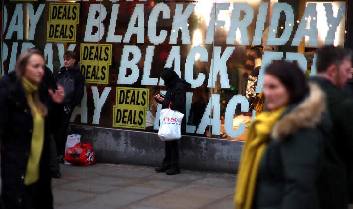People walk past a shop offering Black Friday deals in Manchester