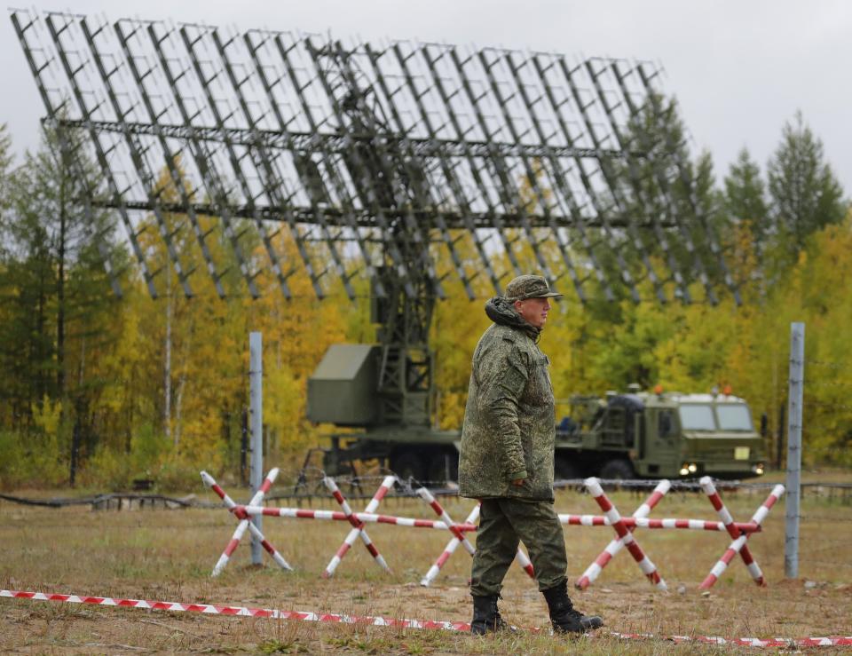 A Russian walks past a Nebo-M radar deployed in a forest, during a military exercises on training ground "Telemba", about 80 kilometers (50 miles ) north of the city of Chita during the military exercises Vostok 2018 in Eastern Siberia, Russia, Wednesday, Sept. 12, 2018. Hundreds of thousands Russian troops swept across Siberia on Tuesday in the nation's largest ever war games also joined by China — a powerful show of burgeoning military ties between Moscow and Beijing amid their tensions with the U.S. (AP Photo/Sergei Grits)