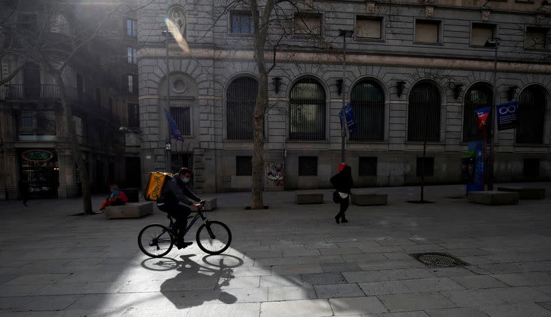 FILE PHOTO: Glovo deliver rider passes through a pedestrian area in Barcelona