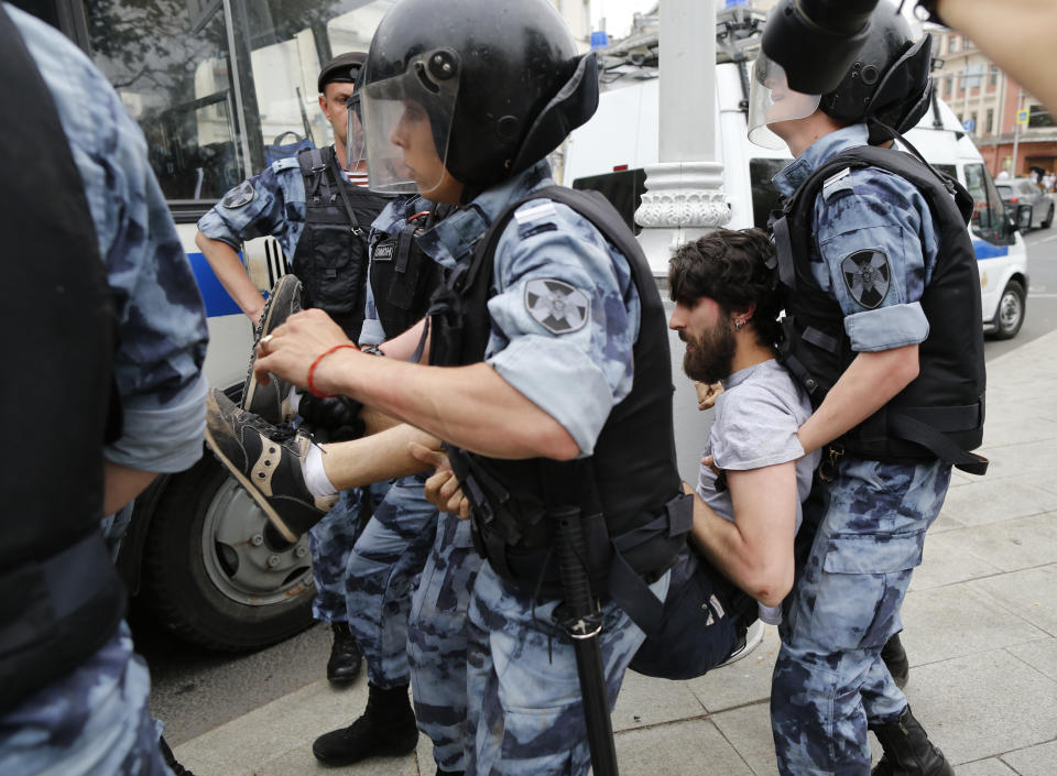 Police officers detain a protester during a march in Moscow, Russia, Wednesday, June 12, 2019. Police and hundreds of demonstrators are facing off in central Moscow at an unauthorized march against police abuse in the wake of the high-profile detention of a Russian journalist. More than 20 demonstrators have been detained, according to monitoring group. (AP Photo/Alexander Zemlianichenko)