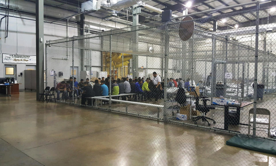 In this photo provided by U.S. Customs and Border Protection, people who've been taken into custody related to cases of illegal entry into the United States, sit in one of the cages at a facility in McAllen, Texas, Sunday, June 17, 2018. Texas state police officers separated migrant families along the border with Mexico by detaining fathers on trespassing charges and turning over mothers and children to federal officials, the state Department of Public Safety said Thursday, Aug. 3, 2023. (U.S. Customs and Border Protection's Rio Grande Valley Sector via AP, File)