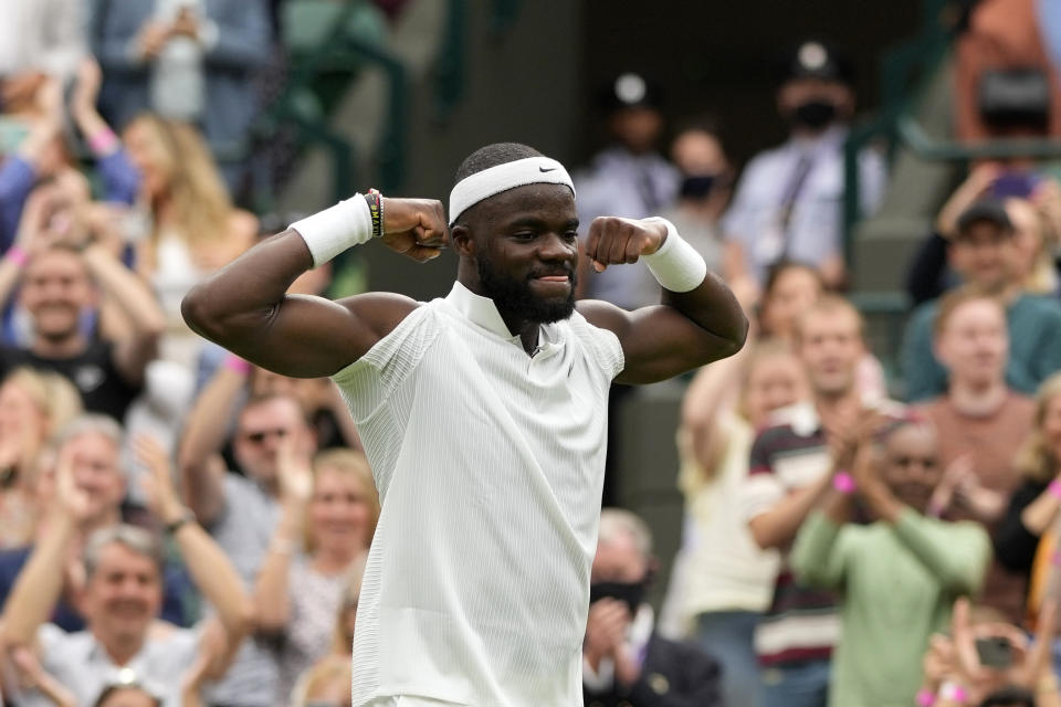 Frances Tiafoe of the US celebrates after winning the men's singles match against Stefanos Tsitsipas of Greece on day one of the Wimbledon Tennis Championships in London, Monday June 28, 2021. (AP Photo/Alastair Grant)