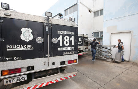 Policemen carry a body at the Institute of Forensic Science in Vitoria, Espirito Santo, Brazil, February 9, 2017. REUTERS/Paulo Whitaker