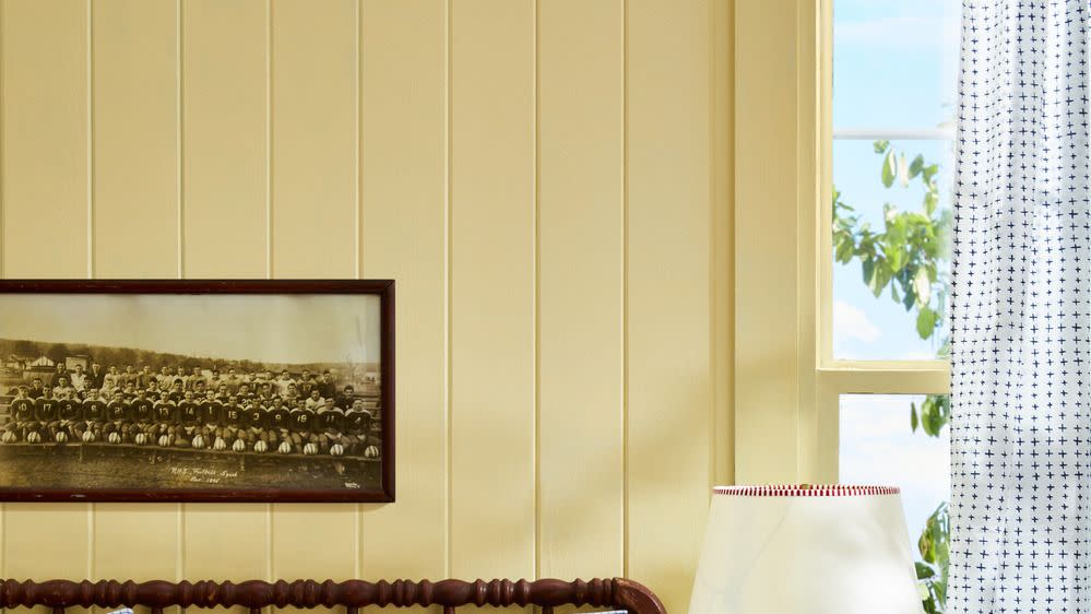 yellow bedroom with college memorabilia decor