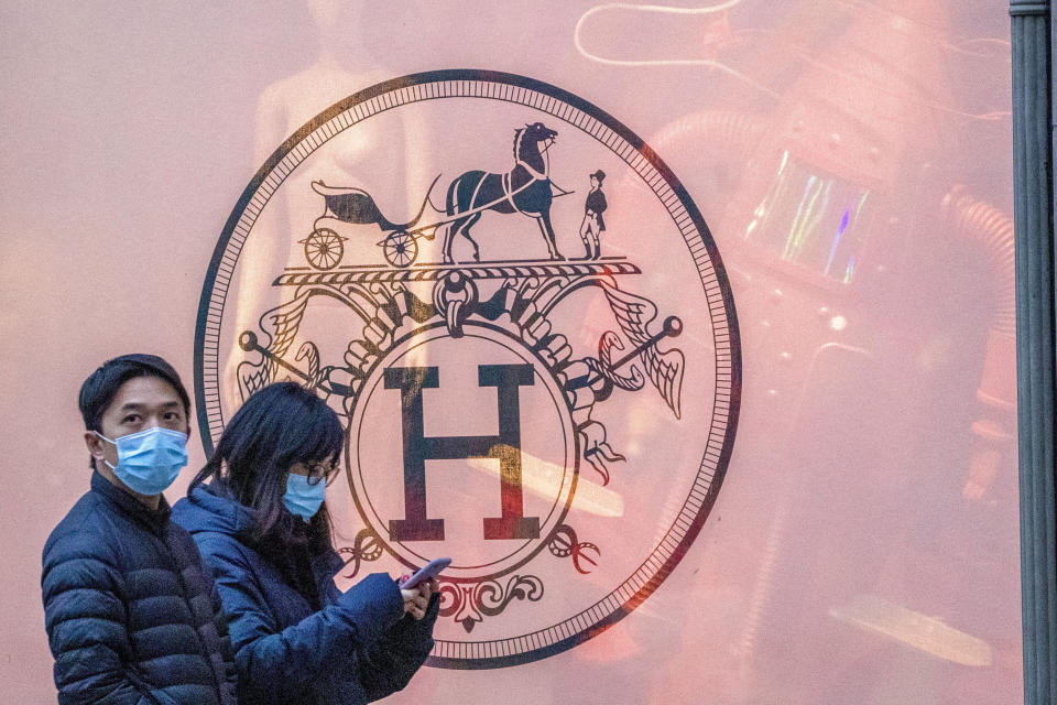 FILE - Pedestrians walk past the Hermes store on Madison Avenue, Thursday, March 19, 2020, in New York. Hermes, the maker of famed bags, is the target of a class action lawsuit, Thursday, March 21, 2024, that claims that the luxury retailer unlawfully prevents customers who have not spent enough at its stores from buying its coveted Birkin handbags. (AP Photo/Mary Altaffer, File)