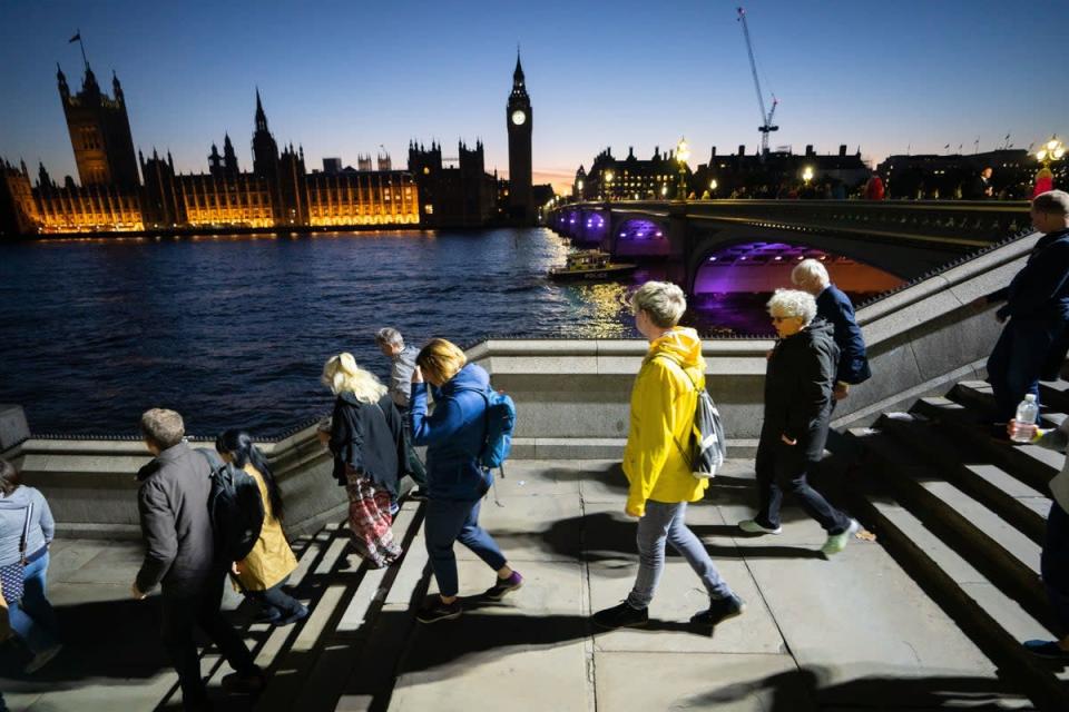 Members of the public queue on the South Bank of the Thames opposite the Palace of Westminster in central London (James Manning/PA) (PA Wire)