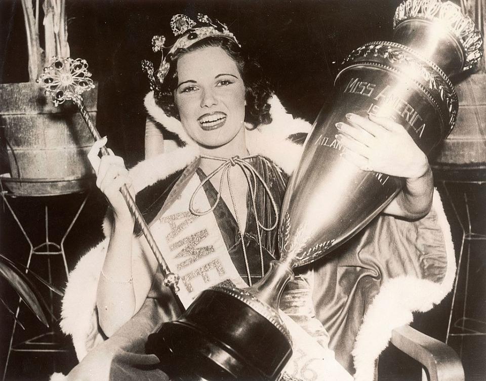 Coyle smiling and holding her trophy