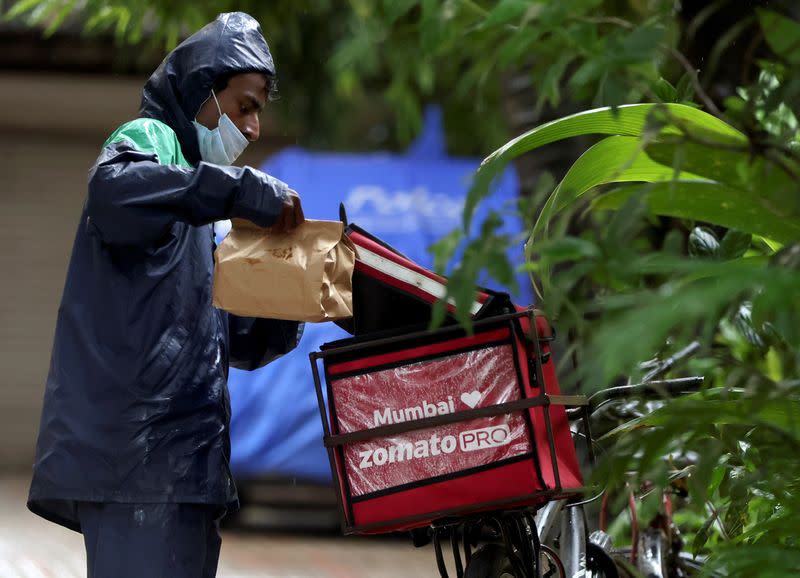 FILE PHOTO: A delivery worker of Zomato picks a food package in Mumbai