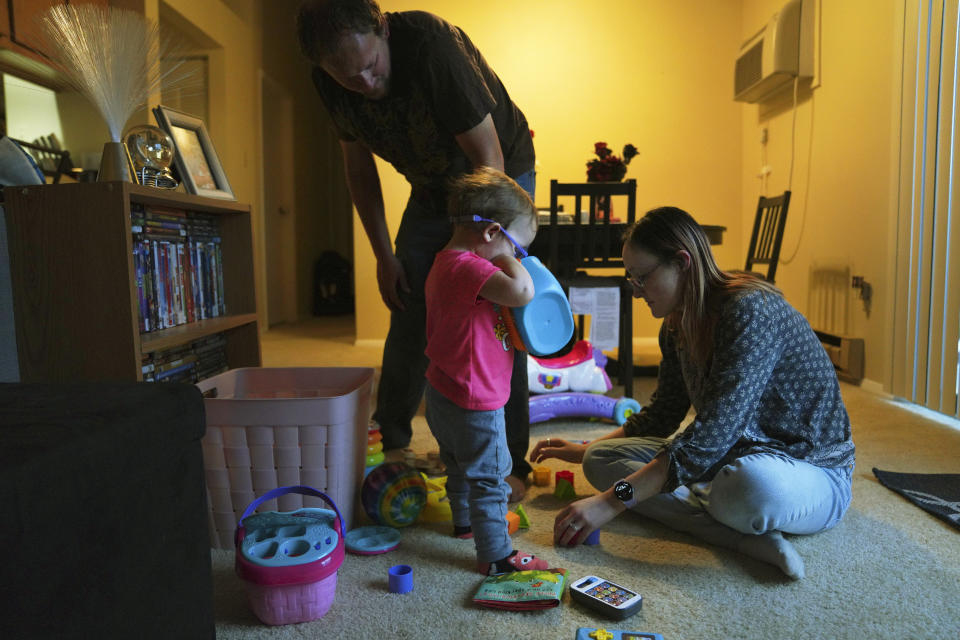 Andrew and Lauren Hackney play with their 1-year-old daughter during a supervised visit at their apartment in Oakdale, Pa., on Thursday, Nov. 17, 2022. The Hackneys’ daughter was taken from their custody at 8 months old when the couple brought her to the children's hospital in Pittsburgh after having difficulty feeding her. They believe hospital staff alerted the Allegheny County Department of Human Services because the baby was severely dehydrated and malnourished. (AP Photo/Jessie Wardarski)