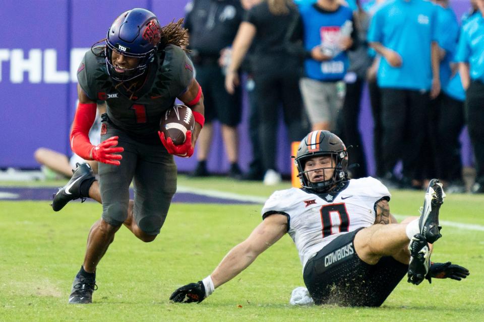 TCU wide receiver Quentin Johnston (1) runs with the ball in front of Oklahoma State linebacker Mason Cobb (0) during the second half of an NCAA college football game in Fort Worth, Texas, Saturday, Oct. 15, 2022. (AP Photo/Sam Hodde)