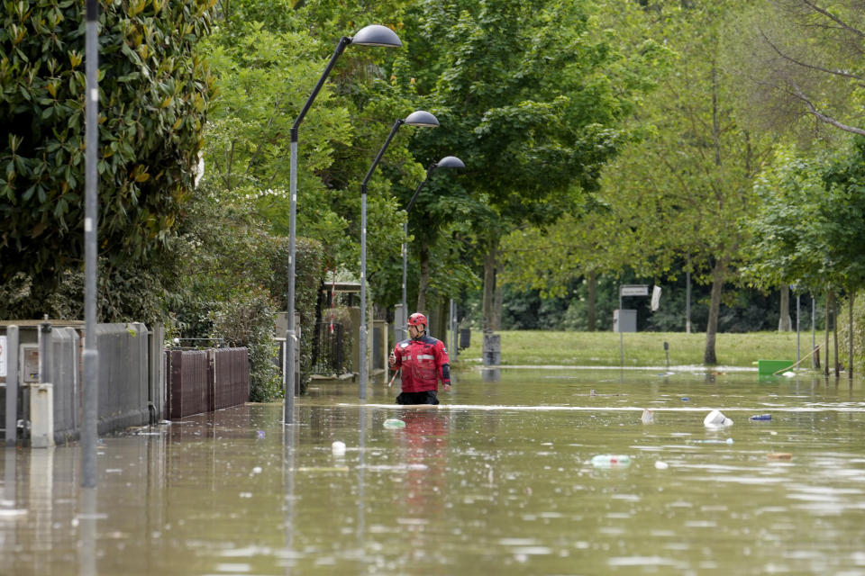 A rescuer walks in a flooded road in Faenza, Italy, Thursday, May 18, 2023. Exceptional rains Wednesday in a drought-struck region of northern Italy swelled rivers over their banks, killing at least eight people, forcing the evacuation of thousands and prompting officials to warn that Italy needs a national plan to combat climate change-induced flooding. (AP Photo/Luca Bruno)