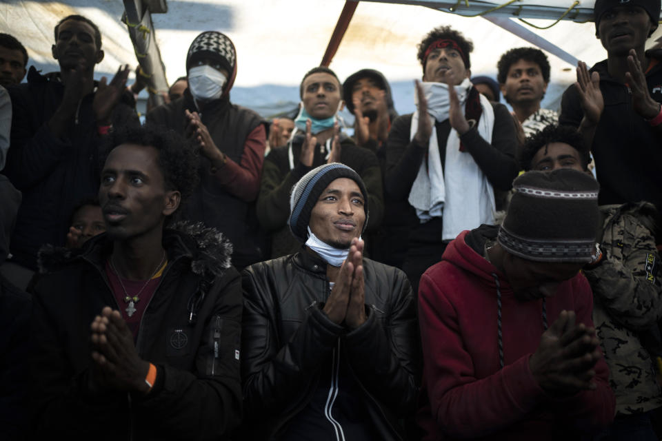 Yohaness, from Eritrea, prays with other migrants as they arrive at the coast of Italy aboard the Spanish vessel Open Arms, on Jan. 4, 2021, after being rescued in the Mediterranean sea. (AP Photo/Joan Mateu)