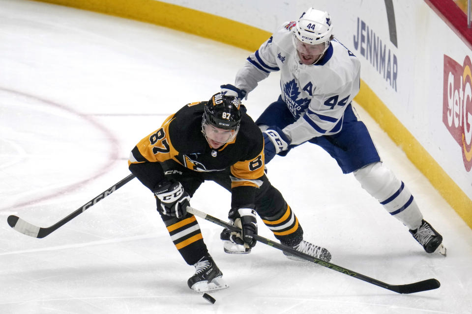 Pittsburgh Penguins' Sidney Crosby (87) controls the puck with Toronto Maple Leafs' Morgan Rielly defending during the first period of an NHL hockey game in Pittsburgh, Saturday, Nov. 25, 2023. (AP Photo/Gene J. Puskar)