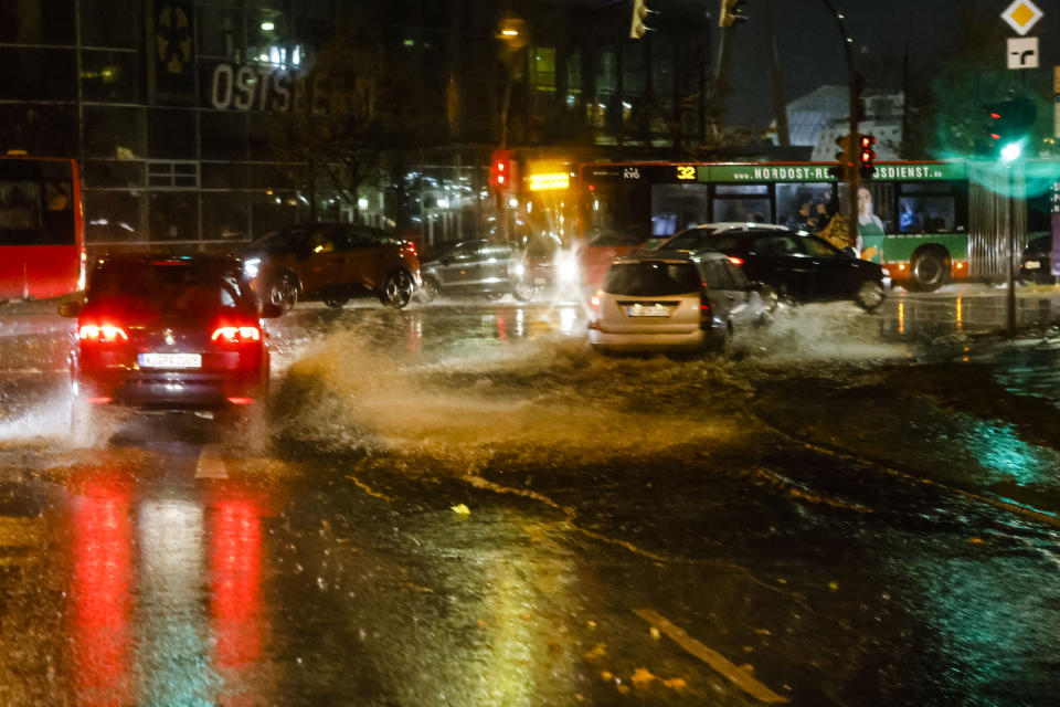 Cars make their way through a flooded road in Kiel, Germany, Thursday, Oct. 21, 2021. Germany is hit by heavy rain and storms. (Frank Molter/dpa via AP)