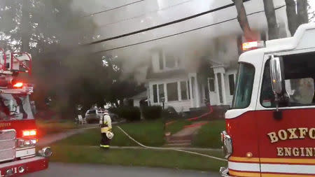 Firefighters work near a building emitting smoke after explosions in North Andover, Massachusetts, United States in this September 13, 2018 still image from social media video footage by Boston Sparks. Boston Sparks/Social Media/via REUTERS