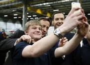 Britain's Prime Minister David Cameron (C) and Chancellor of the Exchequer George Osborne (R) pose for a selfie photograph with an apprentice during a visit to the Spooner engineering works in Ilkley, northern England February 5, 2015. REUTERS/Phil Noble (BRITAIN - Tags: POLITICS BUSINESS)