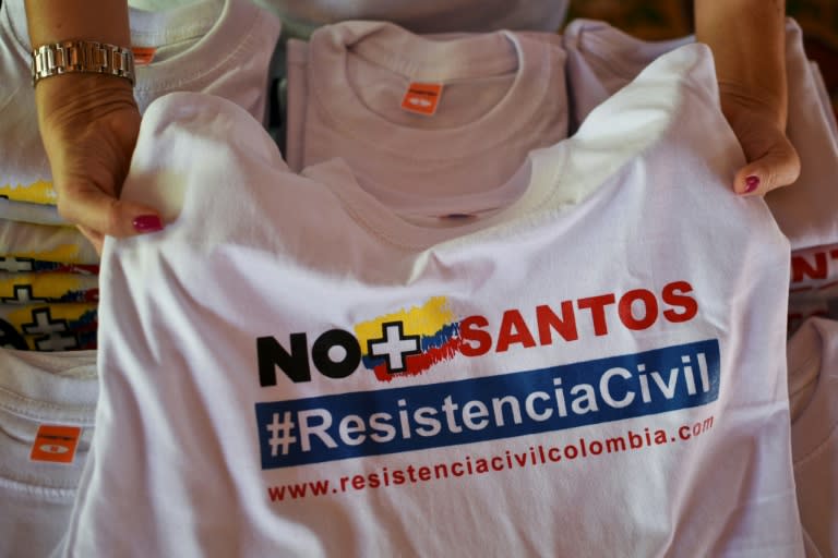 A woman shows a T-shirt reading "No more Santos" during a protest in Cali, Colombia against peace talks between the Colombian government lead by President Juan Manuel Santos and the FARC guerrillas